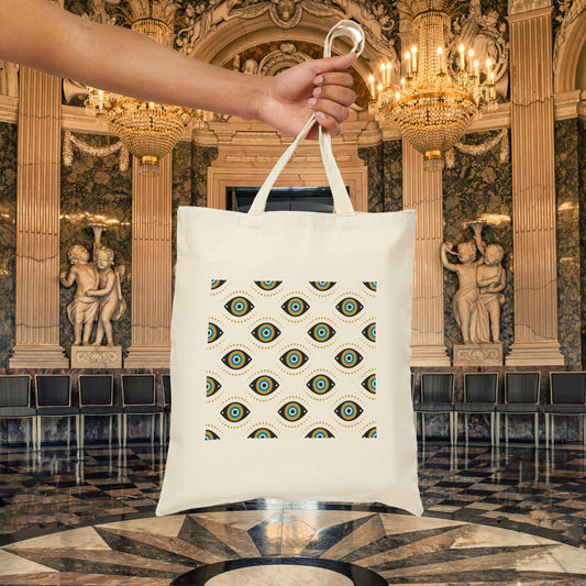 White canvas tote bag with green and black evil eye pattern named Green Eyes